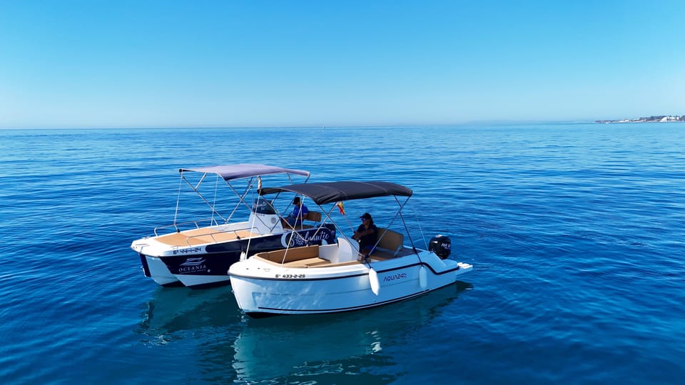 Two small open motorboats with canopies side by side on calm deep-blue sea