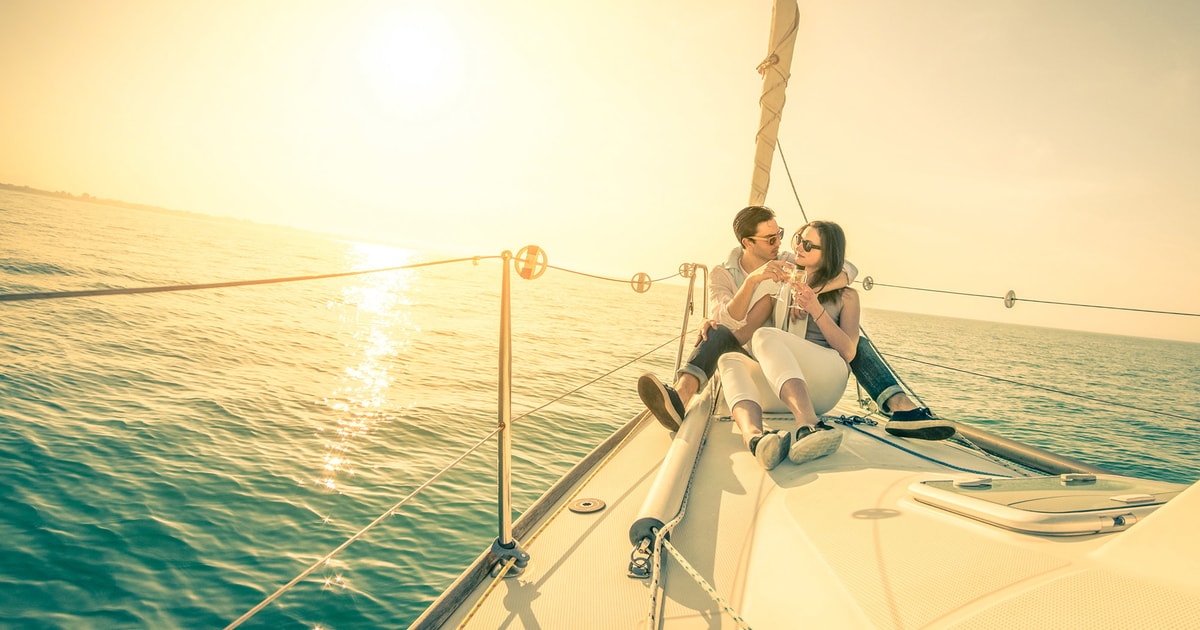 Couple watching the sunset from a private sailing boat on the Tagus