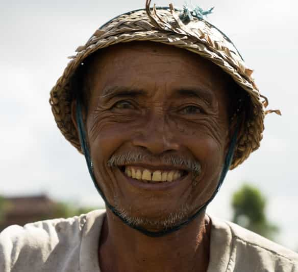 Old Balinese Farmer With Wrinkled Face In Traditional Straw Hat