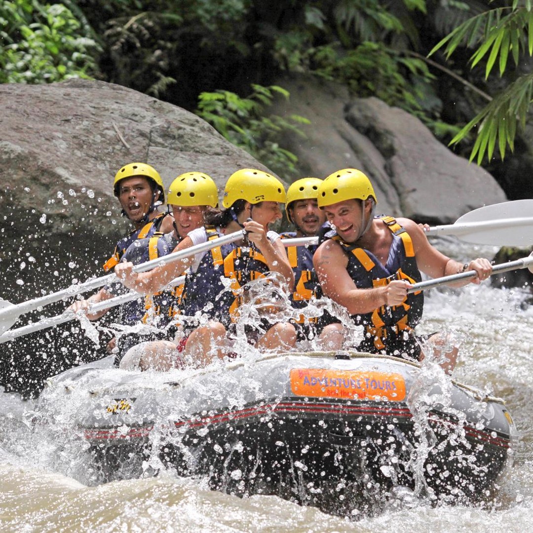 Rafters in helmets and life jackets navigating white water on Bali’s Ayung River