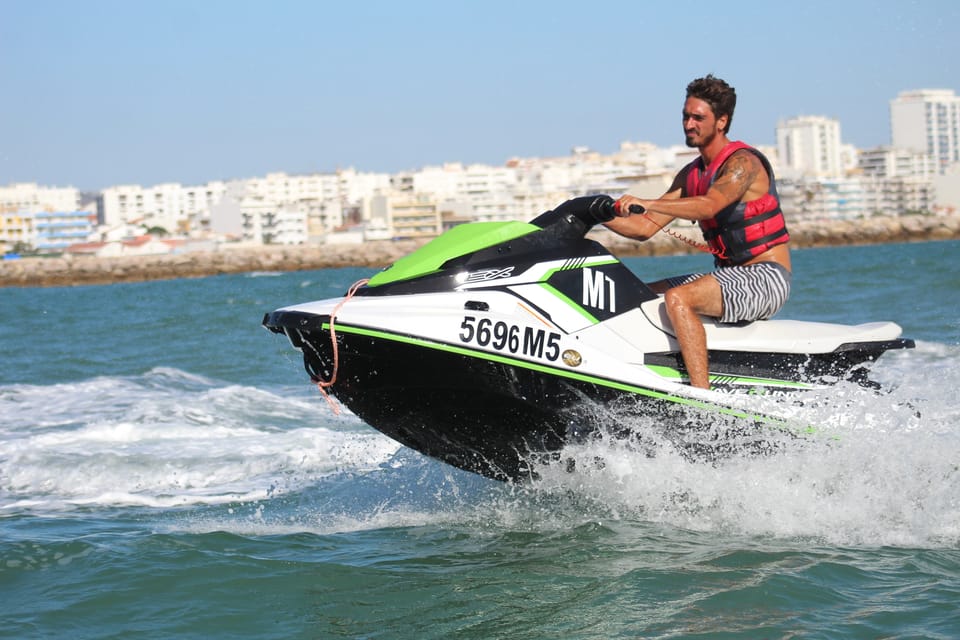 Fahrer mit roter Rettungsweste auf einem grün-weißen Jetski
