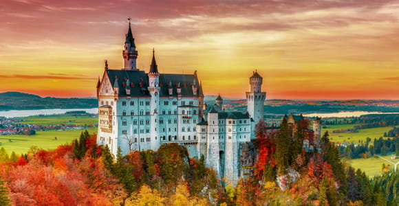 Visitors queuing on the forecourt below the white walls of Neuschwanstein Castle