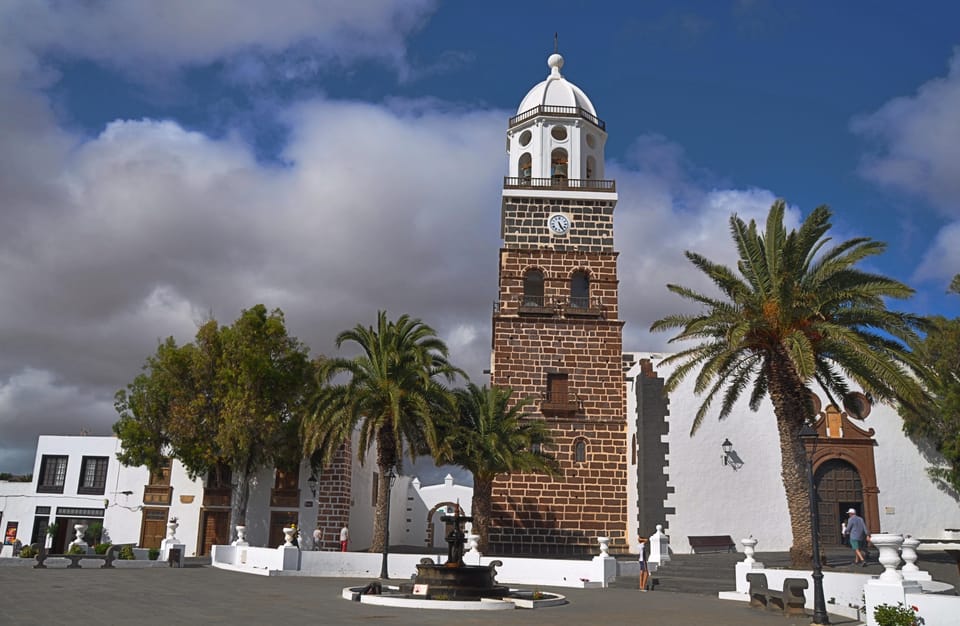 Low white houses with flat roofs spread across dark volcanic ground on Lanzarote
