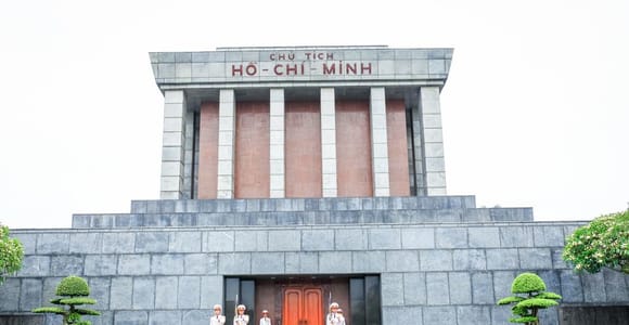 The stone Ho Chi Minh Mausoleum stands beyond a broad ceremonial square in Hanoi