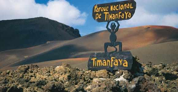 A coach road winding between black and rust-red volcanic slopes