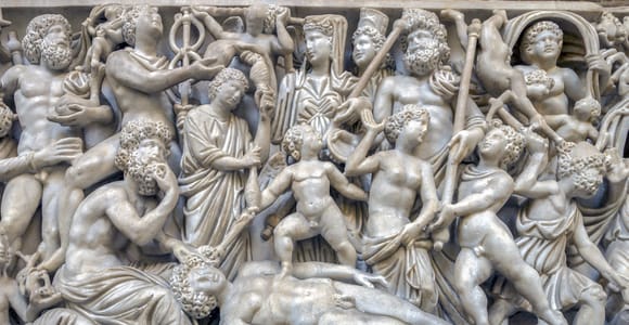 Marble statues arranged beneath high vaulted ceilings in the Naples National Archaeological Museum