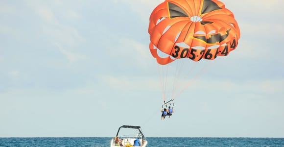Parasail canopy carrying two people above Boracay’s blue coastline
