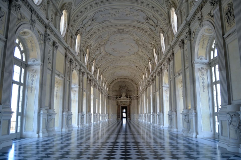 Long Baroque gallery with a patterned stone floor and tall arched windows