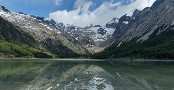 Türkisfarbene Berglagune zwischen Torfmoor, Lenga-Wald und verschneiten Gipfeln