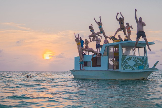 Visit Caye Caulker Sunset Cruise on a Houseboat with Food & Drink in San Pedro
