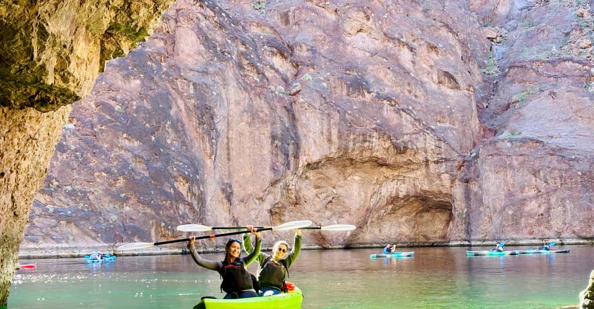 Kayaker inside Emerald Cave, Colorado River — vivid emerald green water illuminated by midday sunlight