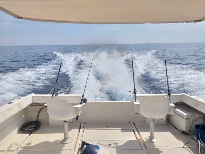 Fishing rods set along the rail of a catamaran on open Mediterranean water