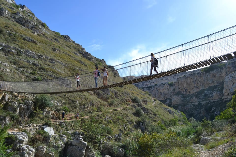 Suspension footbridge crossing a rocky ravine beneath the limestone plateau near Matera
