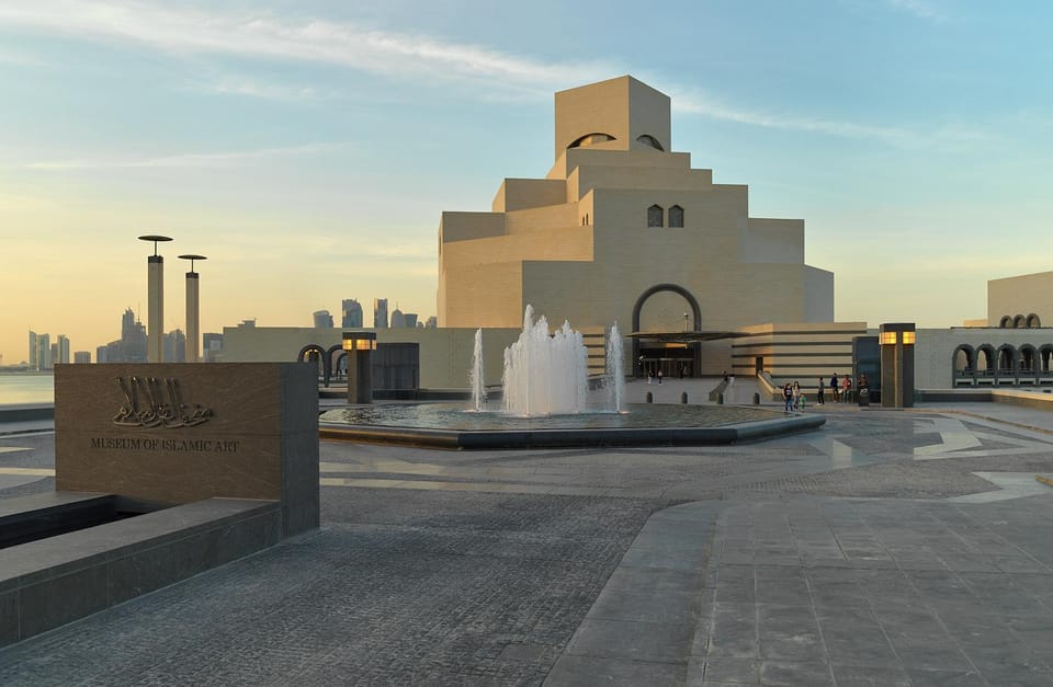The geometric limestone facade of the Museum of Islamic Art beside Doha Bay