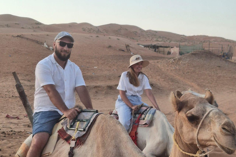 Mascate: Passeio de camelo ao pôr do sol no deserto de Bidiya com transfer