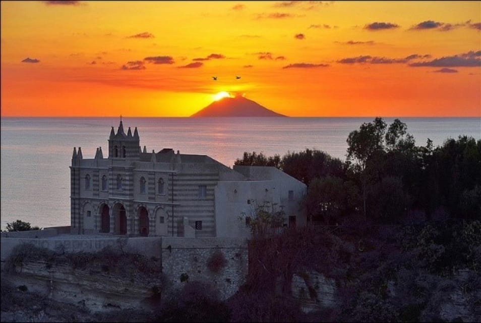 The church of Santa Maria dell’Isola on its rock above the sea, with the silhouette of Stromboli behind it at sunset
