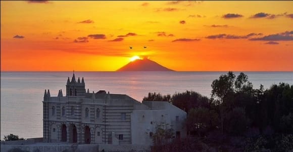 The church of Santa Maria dell’Isola on its rock above the sea, with the silhouette of Stromboli behind it at sunset