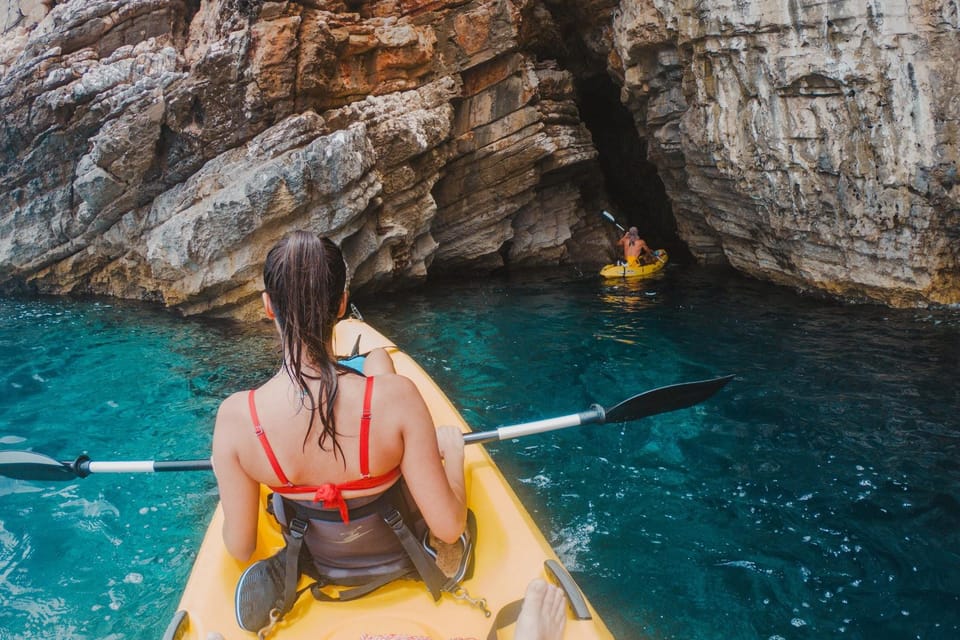 Kayaks beside the rocky coast and clear water near Sant’Angelo