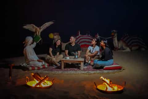 Camel caravan at dusk with stargazing sky in the Dubai desert