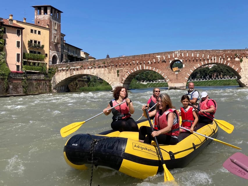 Raft moving along the Adige beneath historic bridges and ochre riverfront buildings in Verona