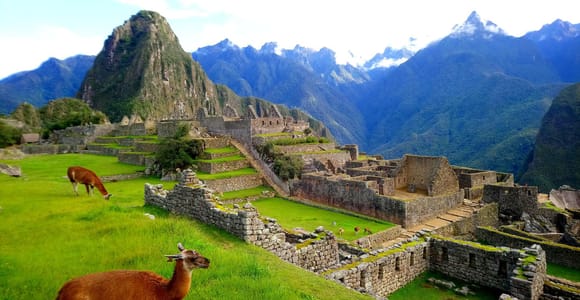 Stone Inca path crossing a green Andean mountain slope