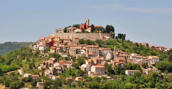 Rovinj old town rising above the Adriatic with tightly packed pastel houses and a church tower