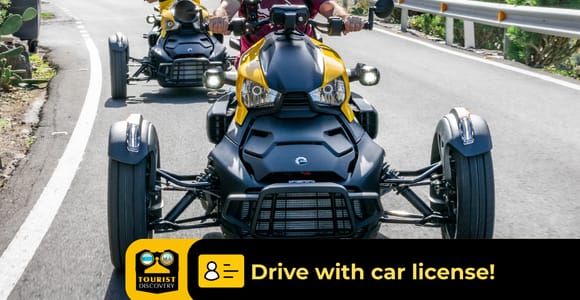 Two three-wheeled road vehicles parked at a mountain viewpoint above Gran Canaria ravines