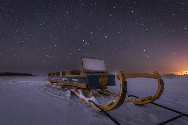 Visit Ii Snowmobile sleigh trip on frozen sea under starlit sky in Tornio