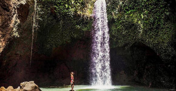 Forest waterfall dropping into a green pool in Bali