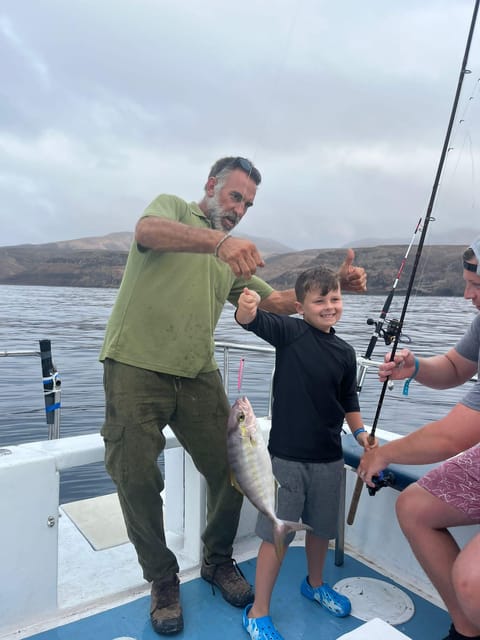 Fishing rods angled over the stern of a small boat on deep blue Atlantic water
