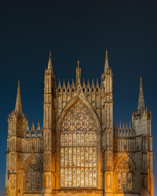York Minster's Gothic stone façade and tall central tower beneath a pale sky