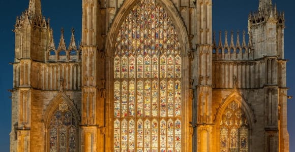 York Minster's Gothic stone façade and tall central tower beneath a pale sky