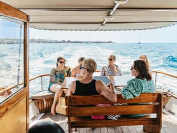 Santorini: Traditionele rondvaart per houten boot met maaltijd en wijn