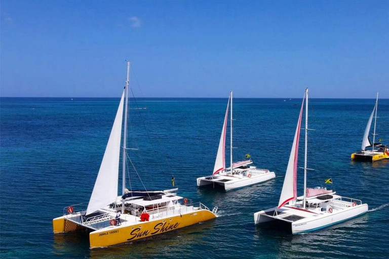 Gezinsvriendelijke catamaran bij zonsondergang in Jamaica met DJ