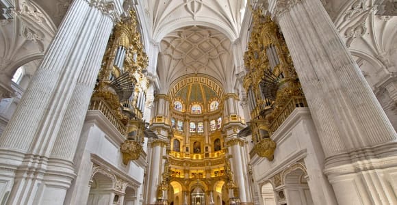 Pale stone columns and a richly decorated altar inside Granada Cathedral