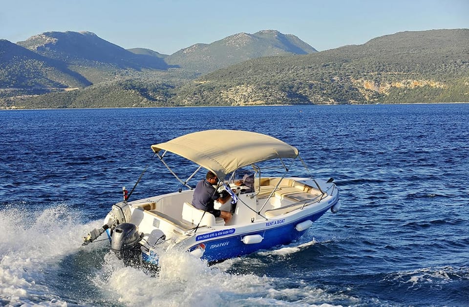A small motorboat with a beige sun canopy speeding through dark blue water, with green hills behind
