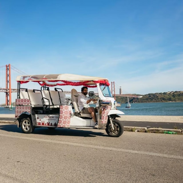 Pink tuk-tuk beside the Tagus River in Lisbon
