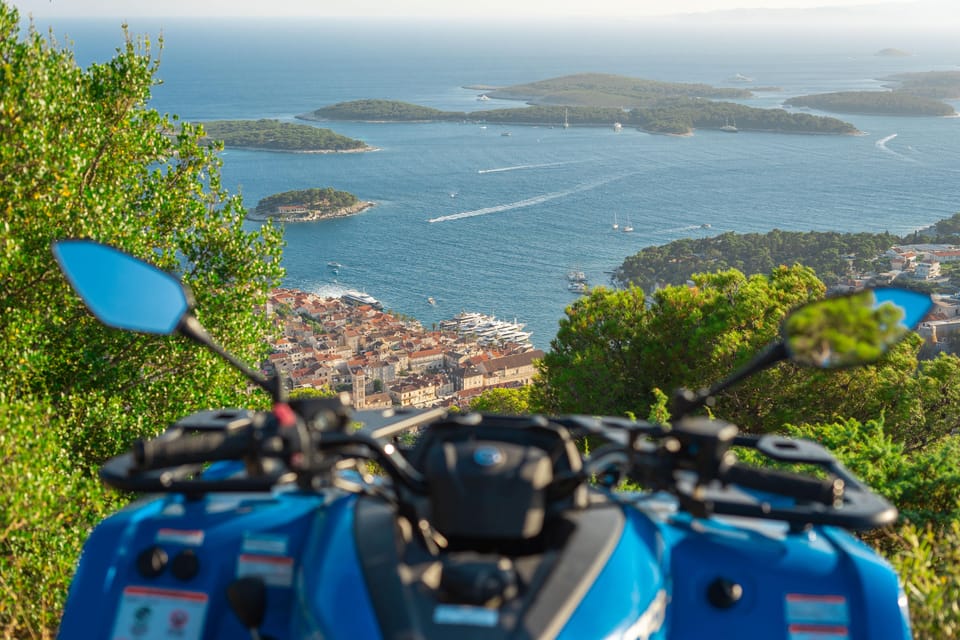 A quad bike stopped on a rocky Hvar track above vineyards and the blue Adriatic