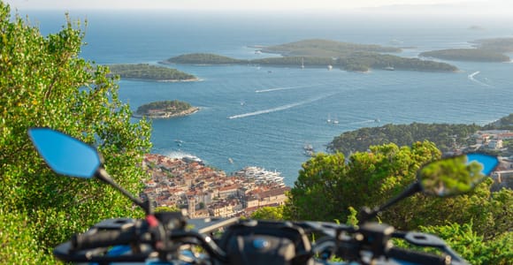 A quad bike stopped on a rocky Hvar track above vineyards and the blue Adriatic