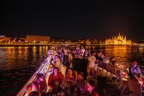 Boat passing the Hungarian Parliament at night on the Danube