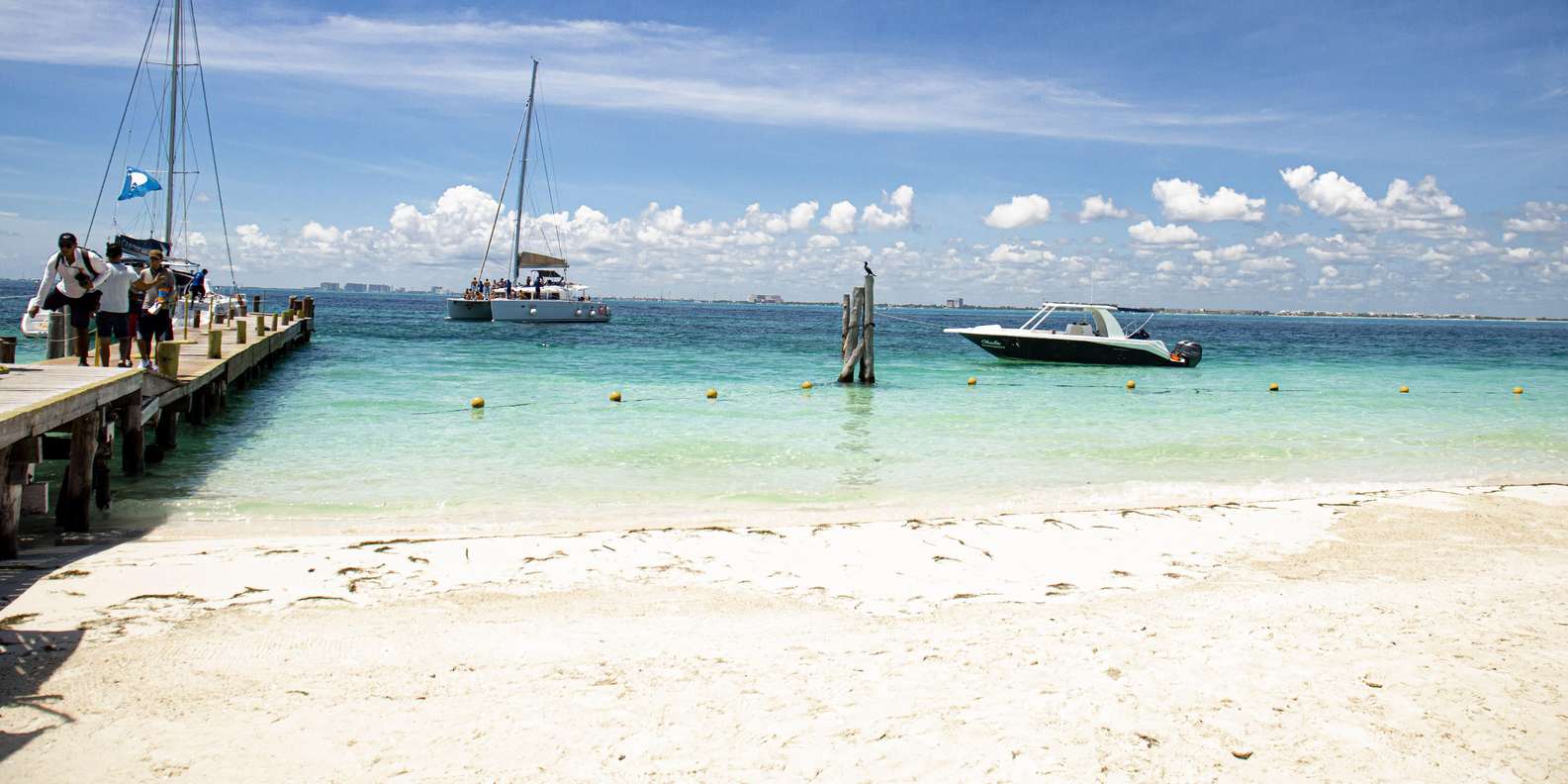 A catamaran sailing the turquoise Caribbean towards Isla Mujeres near Cancun