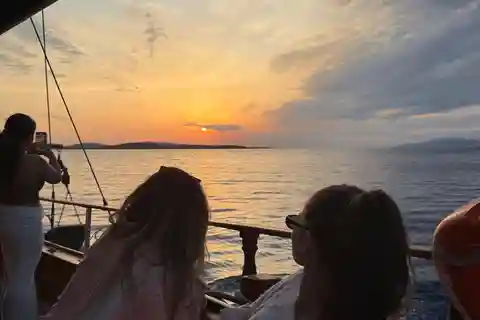 Mykonos: Passeio de barco ao pôr do sol com jantar ligeiro e bebidas