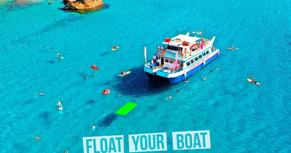 Barco da Float Ibiza junto à costa com participantes na água