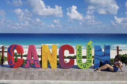Departure to Cancún Airport with a visit to Playa Delfines and the Letters