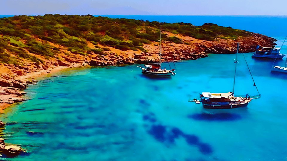 White day boat crossing deep blue water along the rocky Bodrum coast