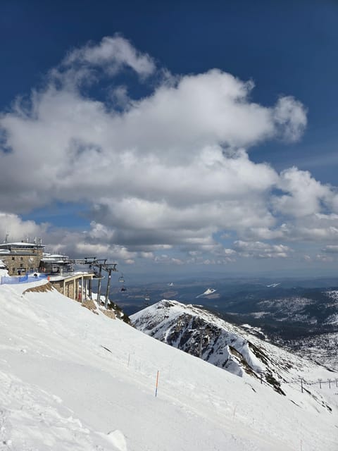 Cable-car summit station on a snowy ridge above a wide valley