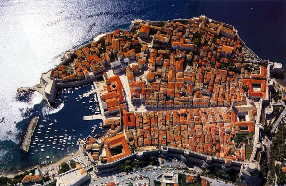 Red-tiled roofs and city walls above the sea in an old walled town
