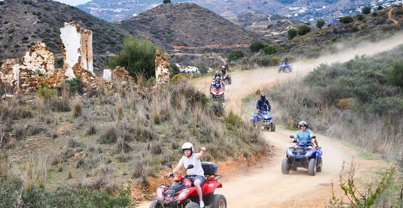 Two quad bikes following a dusty track through the Mijas hills