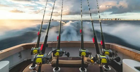 Cannes à pêche à la poupe et sillage écumant du bateau