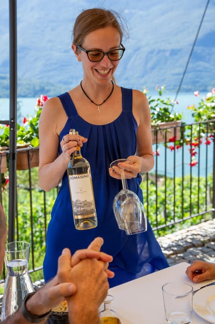 Wine glasses, local cheese and cured meats arranged on a terrace above Lake Como